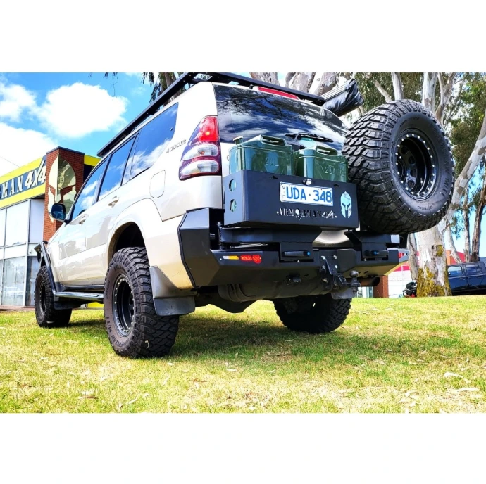 ArmorMan 4x4 Bushmaster Rear Carrier Bar fitted to Toyota Prado 120 Series featuring dual wheel carriers, dual jerry can holders, LED lighting and heavy-duty off-road rear protection