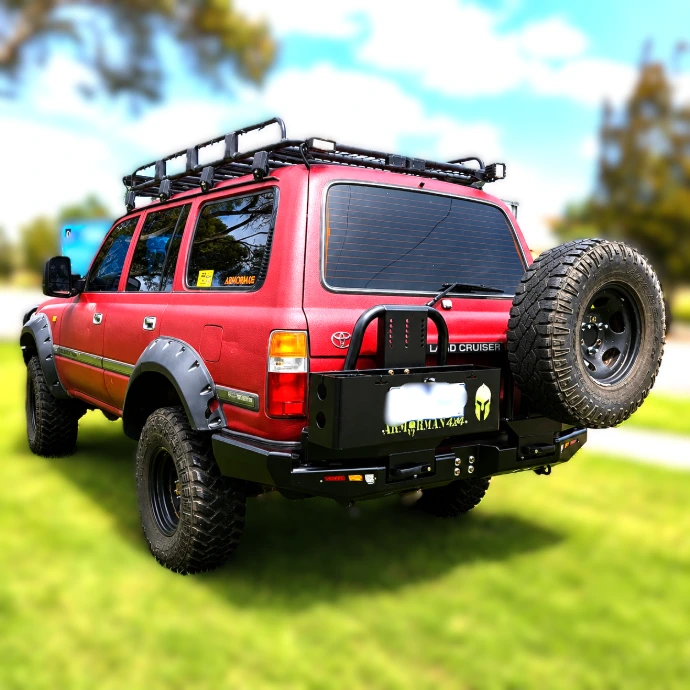 Bushmaster Rear Carrier Bar fitted to Toyota LandCruiser 80 Series with spare wheel carrier and dual jerry can holders.